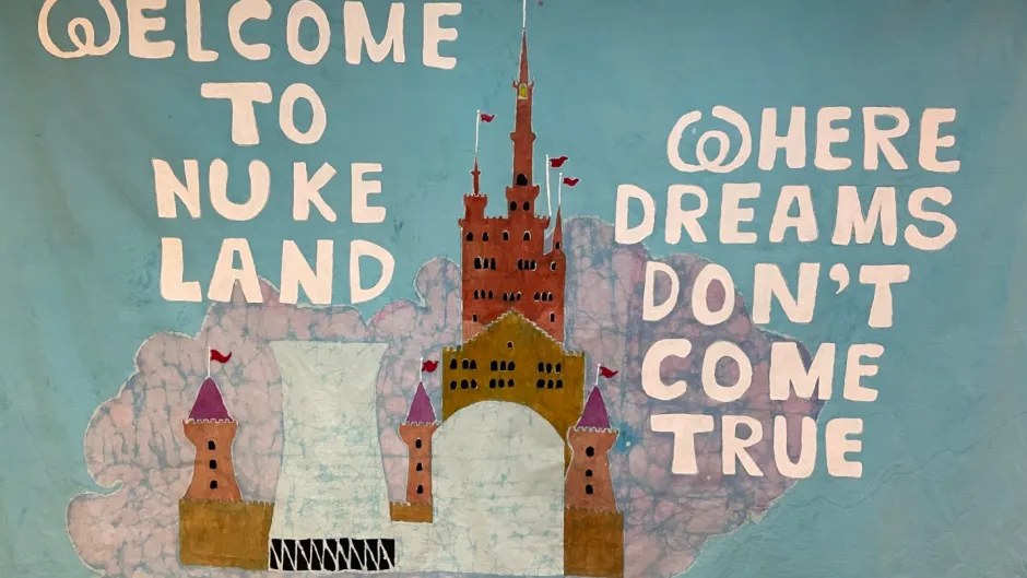Grafik Atomkraftwerk in städtischer Umgebung, Aufschrift "Welcome to nuke land were dreams don´t come true"
